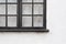 Black window frame with condensation drops on white painted cottage wall