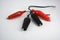 Black wire with red and black insulation, rubber and metal crocodiles for lining to the wire located on a white background.