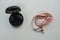 Black wireless bluetooth earbuds and pink wired earphone for music listening