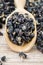 Black wolfberries or black goji berries, in a wooden spoon
