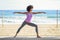 Black woman, afro hairstyle, doing yoga in warrior asana in the