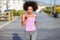 Black woman, afro hairstyle, running outdoors in urban road.