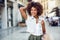 Black woman, afro hairstyle, with shopping bags in the street.