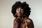 Black woman, beauty and retro fashion, afro hair and blow air kiss with gold makeup and jewelry on studio background