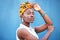 Black woman, beauty and turban for face of african culture, fashion and freedom on a blue background wall for cosmetics