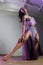 Black woman belly dancing in purple costume