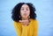 Black woman blowing kiss in air for love, care and flirting on blue background, wall backdrop or outdoor. Young girl