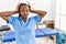 Black woman with braids working at pain recovery clinic doing bunny ears gesture with hands palms looking cynical and skeptical