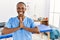 Black woman with braids working at pain recovery clinic praying with hands together asking for forgiveness smiling confident