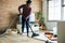Black woman is cleaning living room