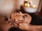 Black woman, closeup of hands on face and massage with masseuse, beauty and bodycare at spa for stress relief and