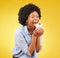 black woman, cupcake and excited or happy in studio while eating sweet food on a yellow background. African female model