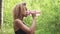 Black woman drinking from pink bottle. Portrait of black young woman taking break while jogging