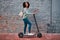 Black woman, electric and scooter in city with smile, happy and relax for summer day, edgy and trendy on sidewalk. Yong