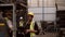 Black woman engineer in safety uniform and helmets to Caucasian man`s forklift driver in warehouse of automobile industry while ot