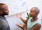 A Black woman gestures in heated discussion with coworker on strategy plan