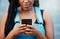 Black woman hands with smartphone for social media, website contact information or reading online blog newsletter in