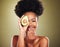 Black woman, laughing or avocado skincare on green studio background for healthcare diet, dermatology wellness or