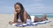 Black woman leaning on hand and lying on beach