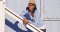 Black woman leaning on wooden rail smiling