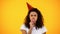 Black woman in party hat blowing noisemaker, celebrating birthday, holiday party
