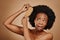 Black woman, problem and brushing hair in studio, brown background and tangled afro. Beauty, unhappy female model and