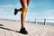 Black woman runner, knee pain and legs by promenade, street or training by ocean in fitness, speed or health. Feet