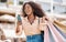 Black woman, shopping bag and city smartphone on social media to search discount codes for fashion sales, online