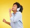 Black woman, singing with headphones and freedom, music and happiness with invisible mic on yellow studio background