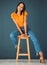 Black woman, smile and portrait of a young model sitting on a stool in a studio. Casual fashion, happiness and youth of