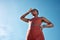 Black woman, tired or sweating in fitness workout or training exercise on blue sky background in healthcare wellness