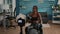 Black woman trainer practicing morning yoga exercise sitting on fitness swiss ball