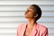 Black woman, with very short hair blowing a kiss.