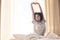 Black woman, wake up and morning stretching in home bedroom after sleeping or resting. Bed relax, peace and comfort of