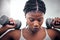 Black woman, weightlifting dumbbells and gym with focus, strong body or muscle for health, wellness and fitness. African