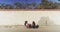 Black women friends sitting in beach chairs in front of old wall