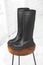 Black women wellington boots. Female autumn and winter footwear on a wooden stand. Modern design photo