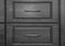 Black wooden chest of with drawers with metal handles closeup