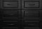 Black wooden chest of with drawers with metal handles closeup