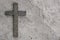Black wooden cross with the Lord`s prayer on the grey concrete with cracks background.