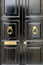 Black wooden door with golden vintage knockers and mail slot letterbox