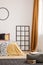 Black wooden grille next to the bed with orange bedding in the bedroom