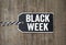 Black wooden hang tag with message Black Week on weathered wood background