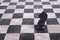 Black wooden knight on chessboard