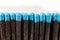 Black wooden matches with bright blue heads on a light gray background close-up. Matchsticks without box