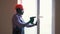 The black worker installing and checking window in the house