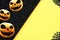 Black and yellow background with three halloween pumpkins and a spider web in the corners.