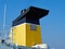 Black and yellow chimney of a cargo ferry ship