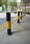 Black and yellow painted steel barrier or bollards beside the road