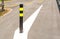 Black and yellow steel bollard.